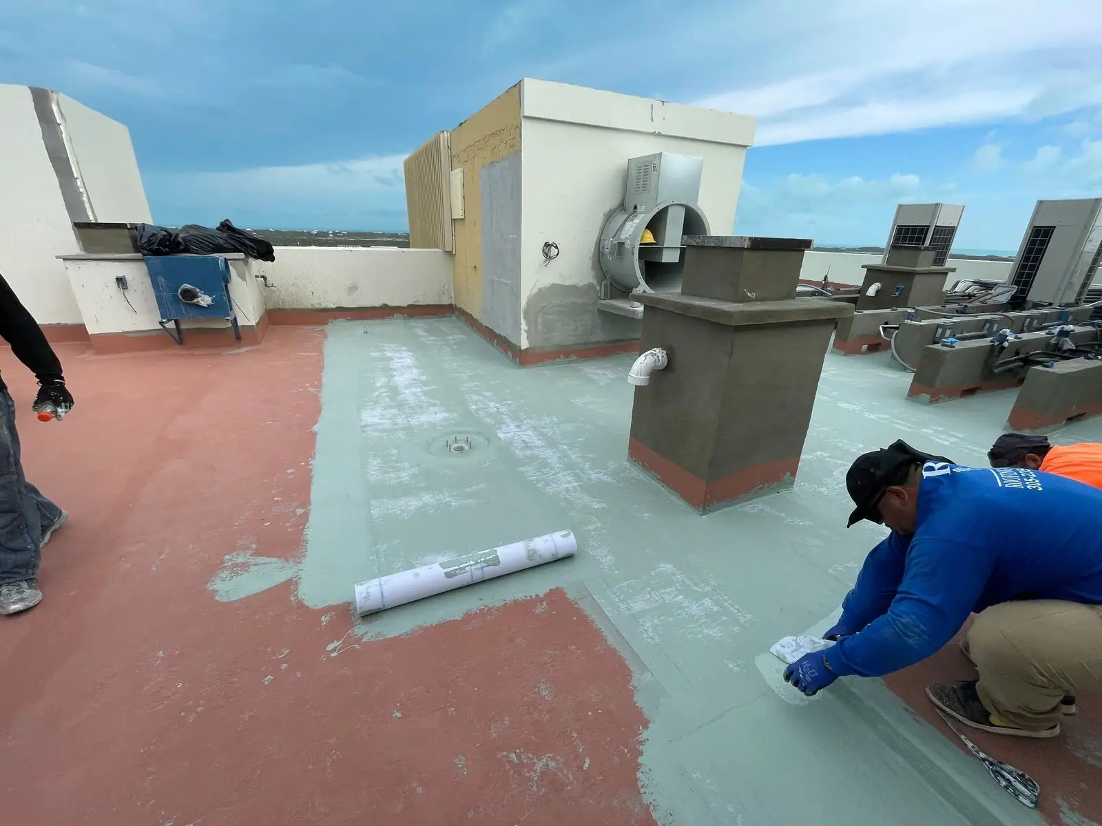 Installer detailing the base coat at the roof edge, St. Regis, Turks and Caicos