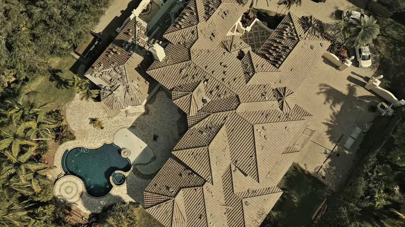 Aerial view of a finished tile roof on a large Pinecrest home with a pool